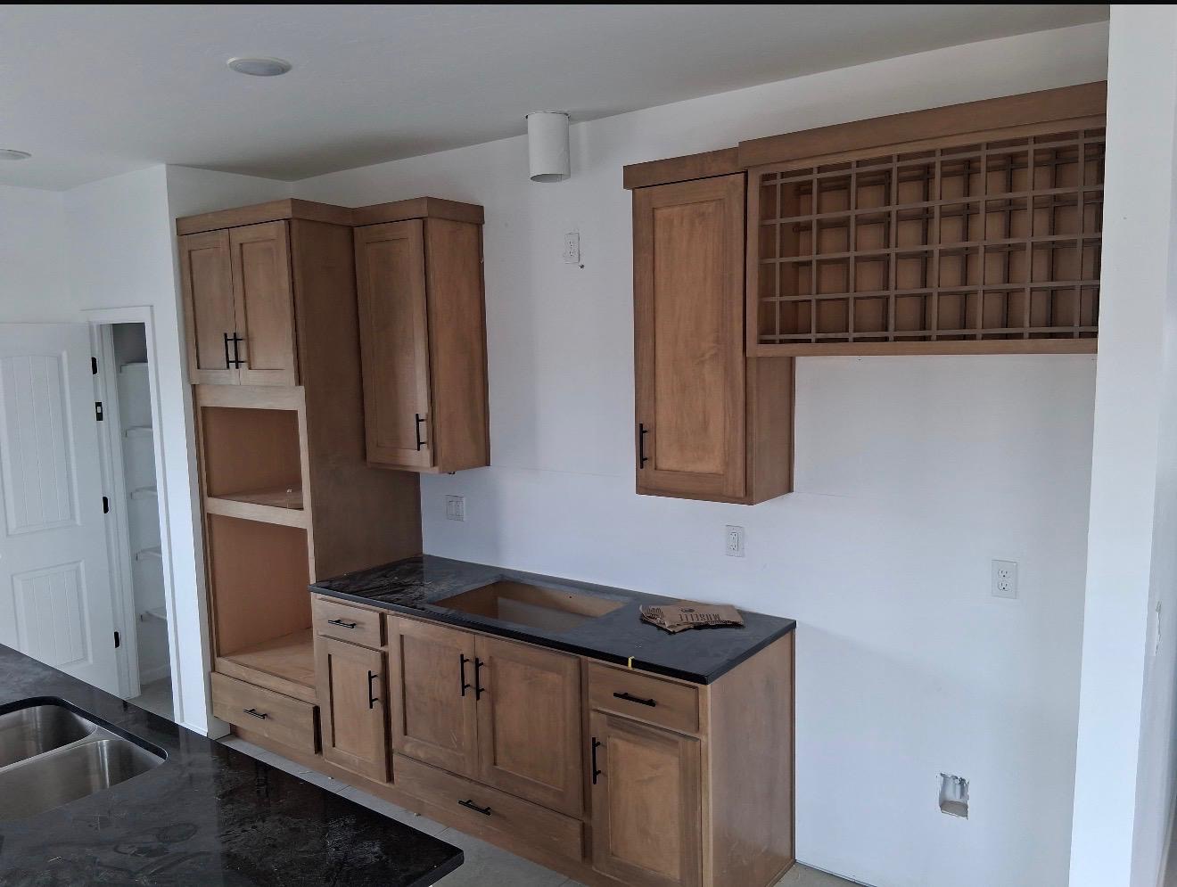 Natural wood bar cabinets with wine rack and granite countertop