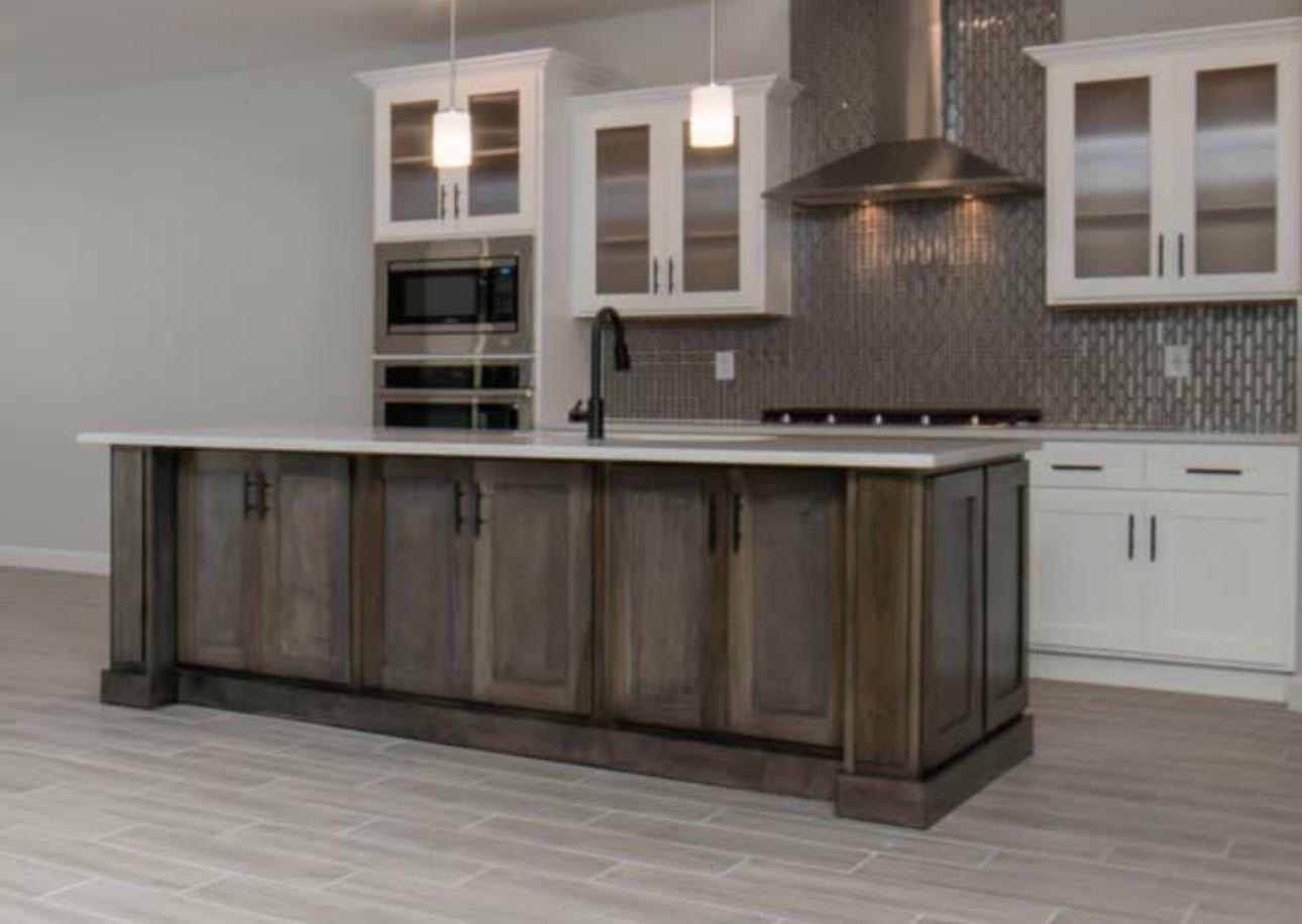 Stained wood kitchen island with white perimeter cabinets