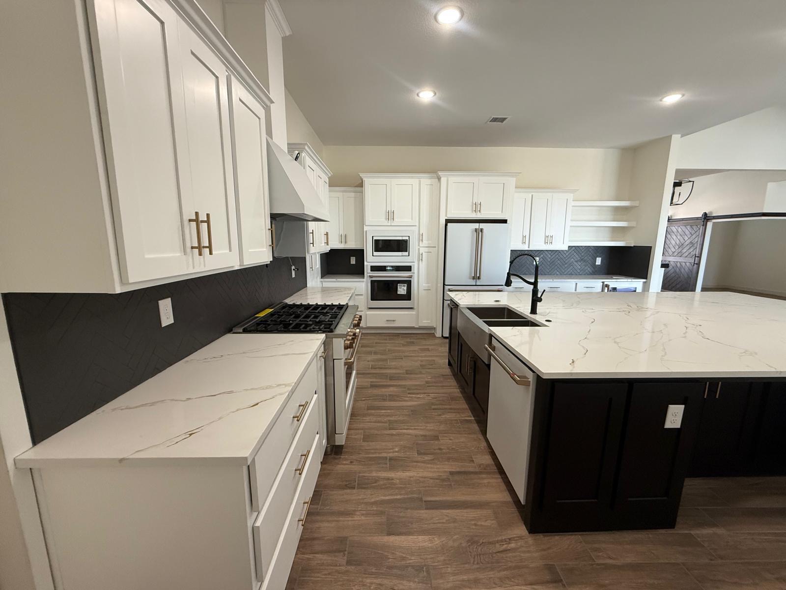 Kitchen with white perimeter cabinets and dark island