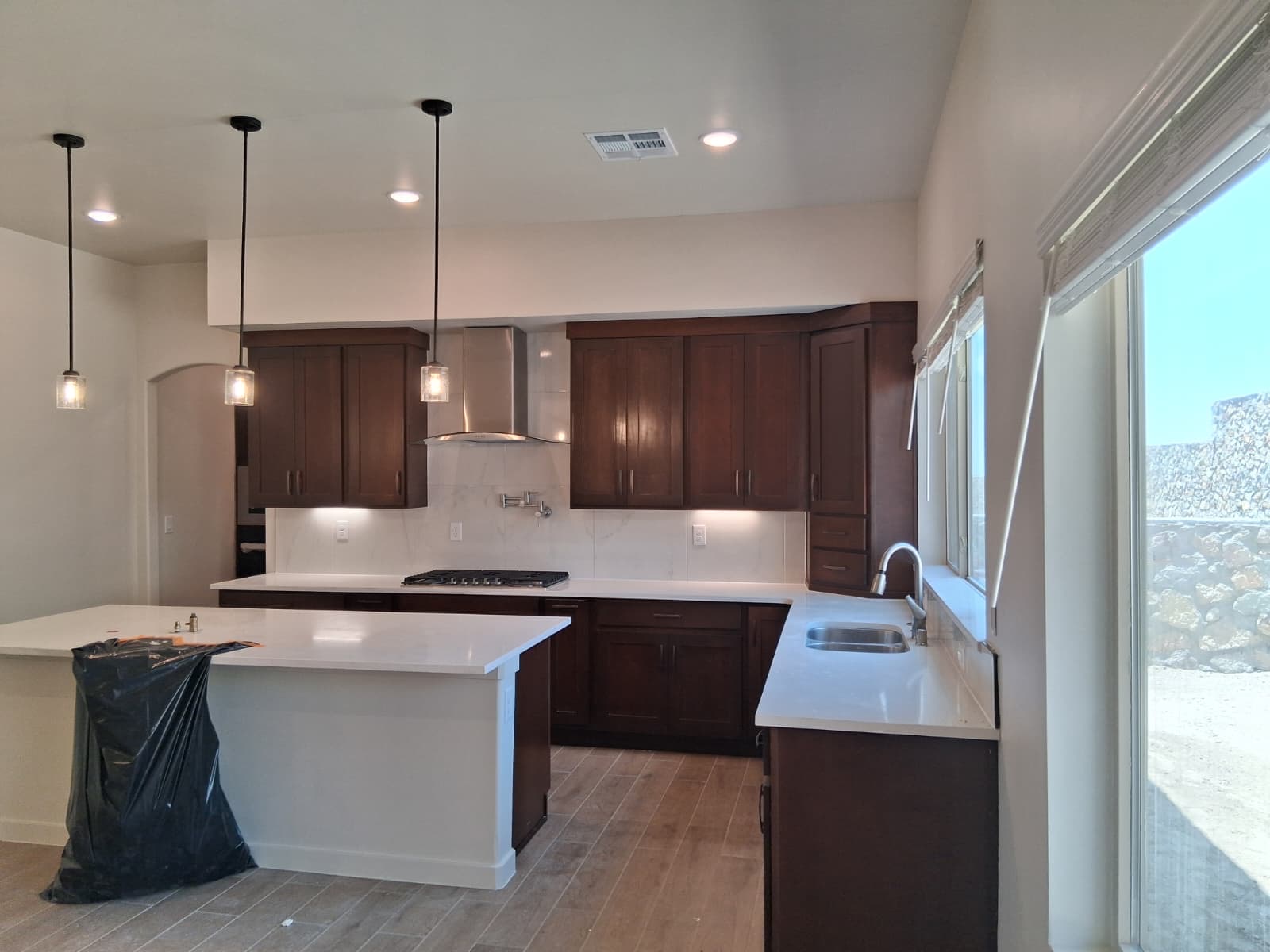 Stained wood kitchen cabinets and island with countertops